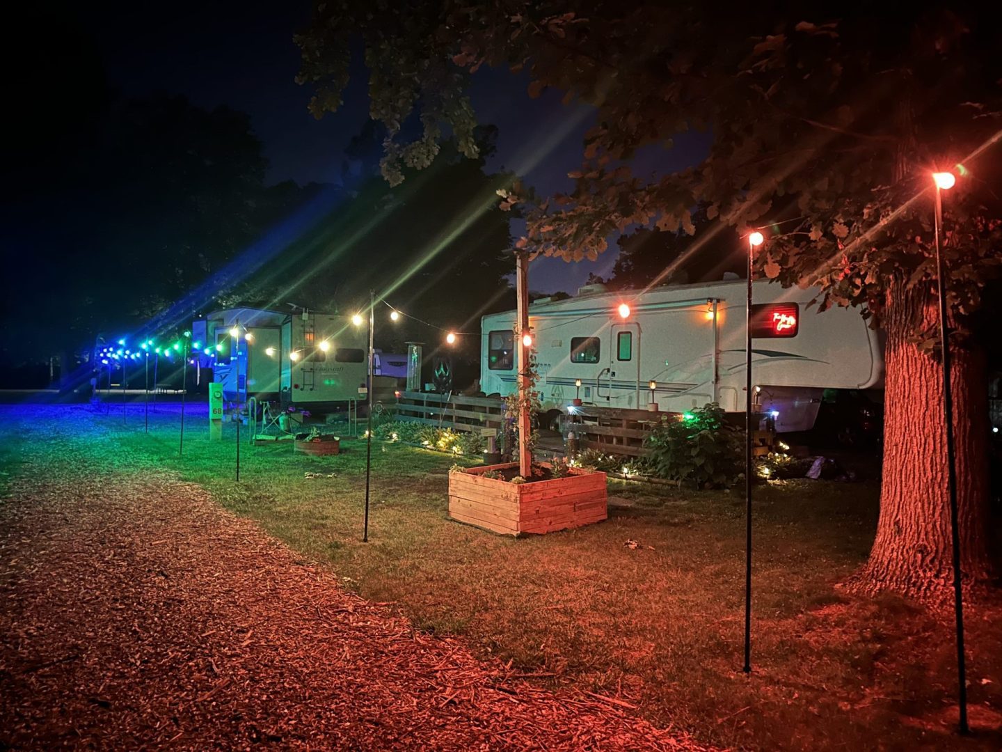 Colorfully illuminated RV campsites at night at CreekRidge Campground.